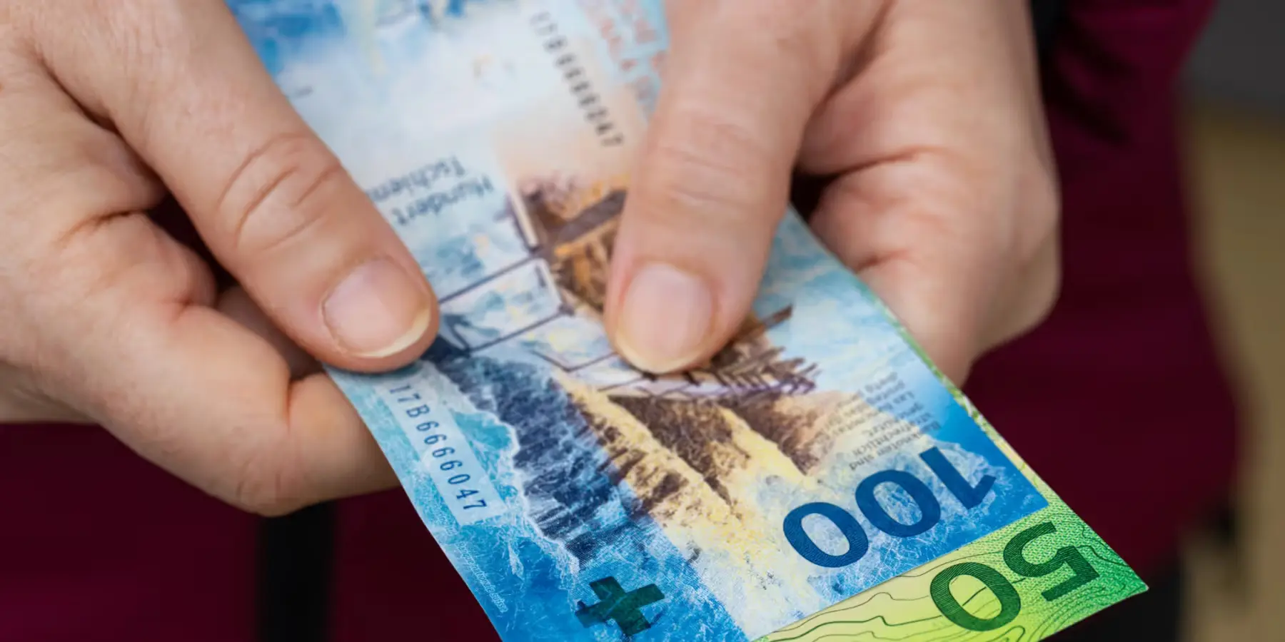 Hände halten Schweizer Franken-Banknoten