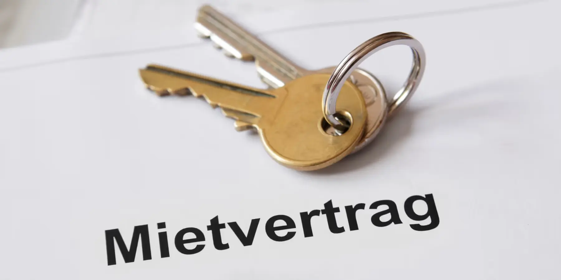 Wohnungsschlüssel liegen auf einem Dokument mit der Aufschrift Mietvertrag