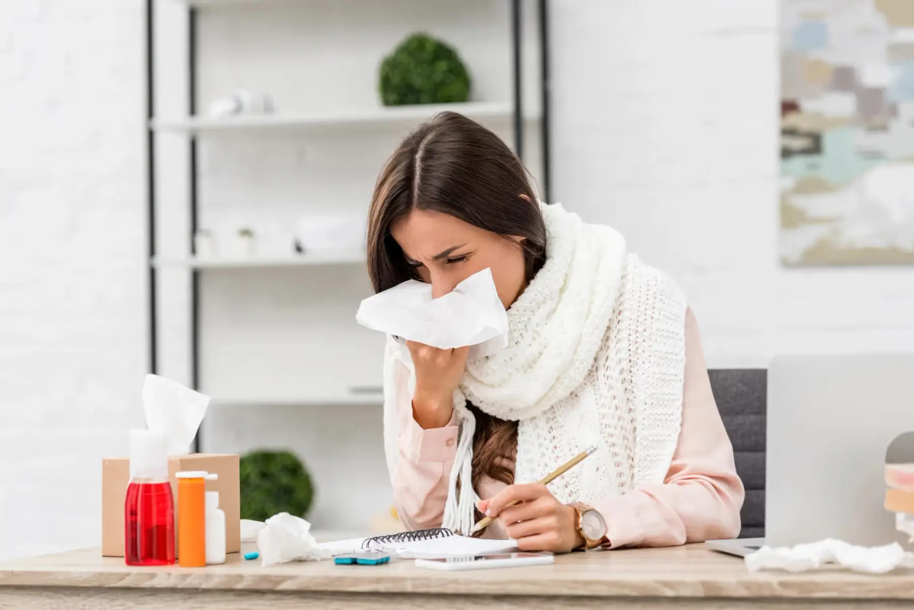 Femme malade au bureau se mouche en travaillant