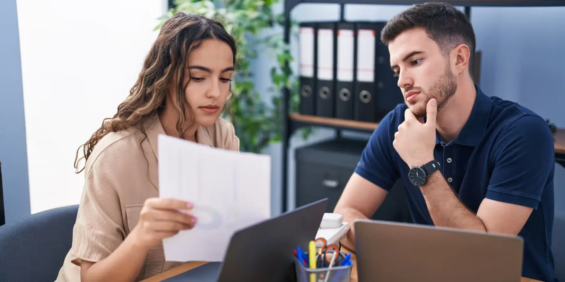Frau und Mann lesen gemeinsam ein Dokument im Büro