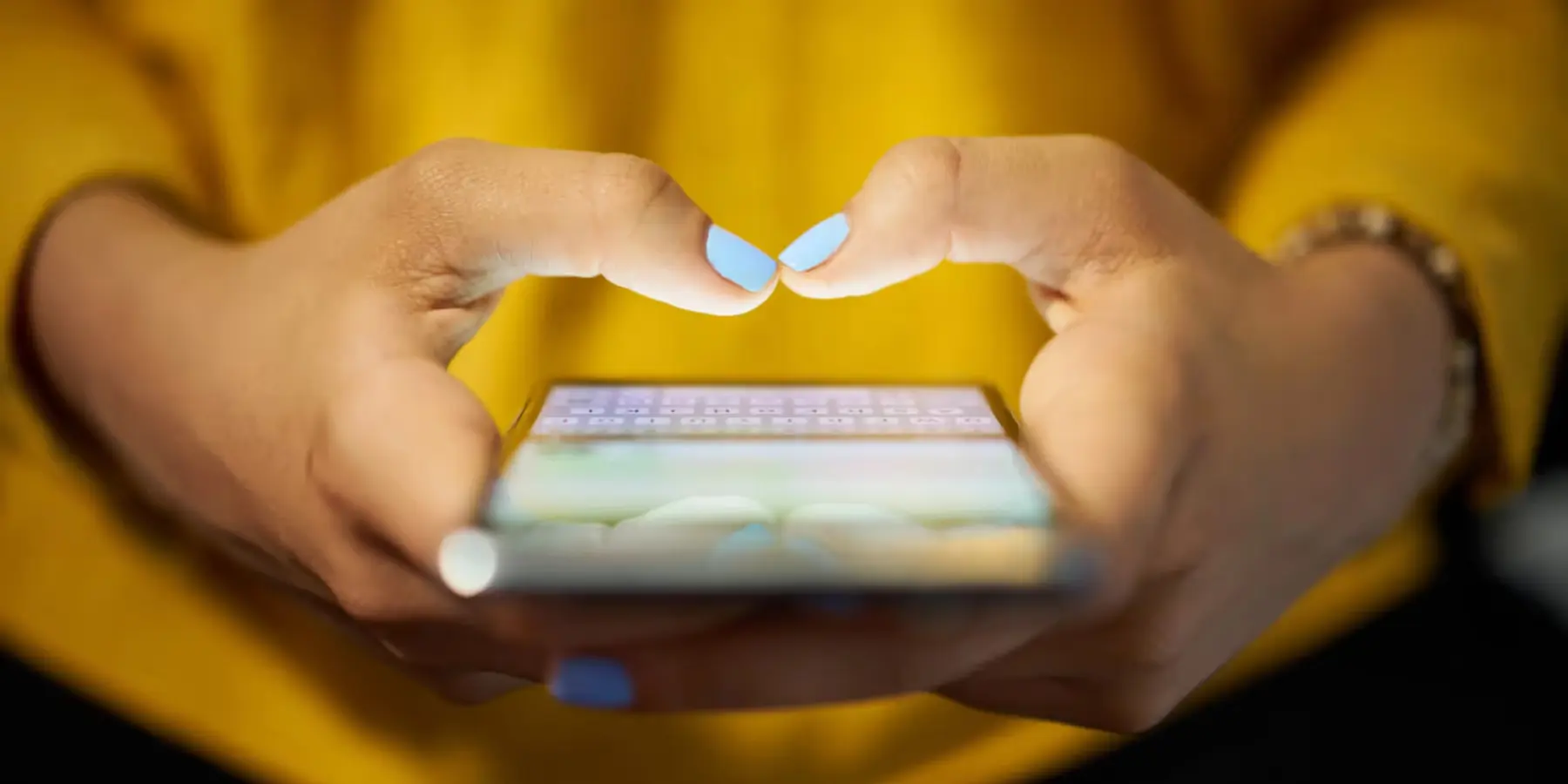 Mains tenant un smartphone affichant une application de messagerie