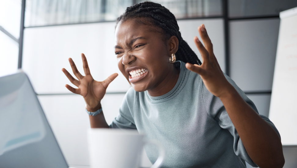 Frau schreit frustriert vor Laptop