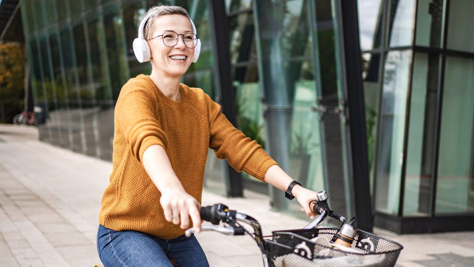 Frau fährt lächelnd Fahrrad in der Stadt
